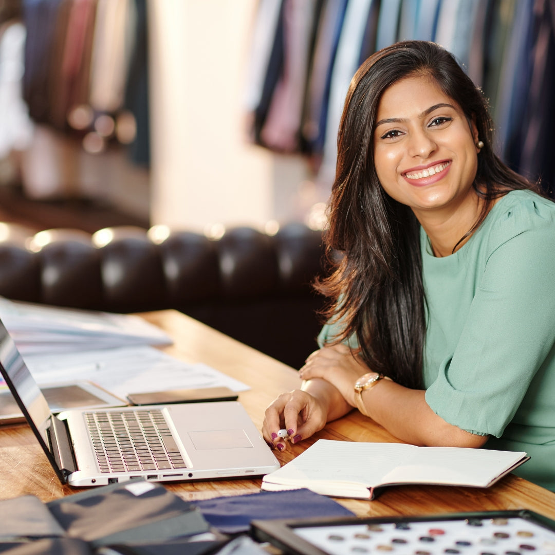 glückliche indische Frau mit Textilien im Hintergrund
